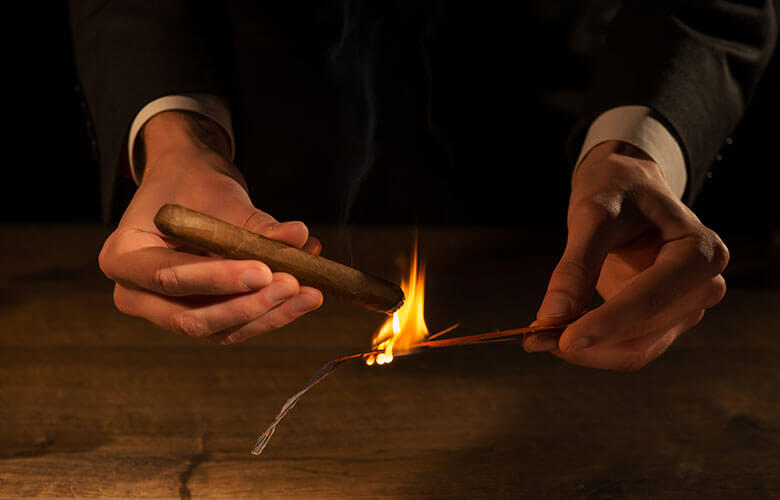 Allumage d'un cigare à l'allumette